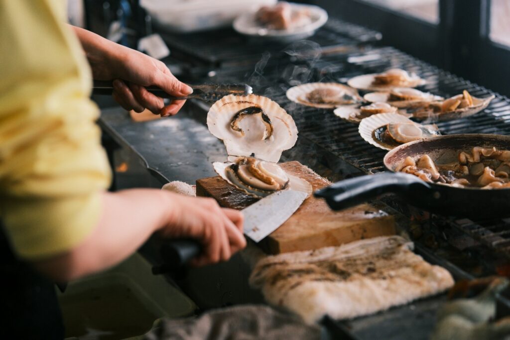Vieiras y pescado a la brasa sobre una parrilla